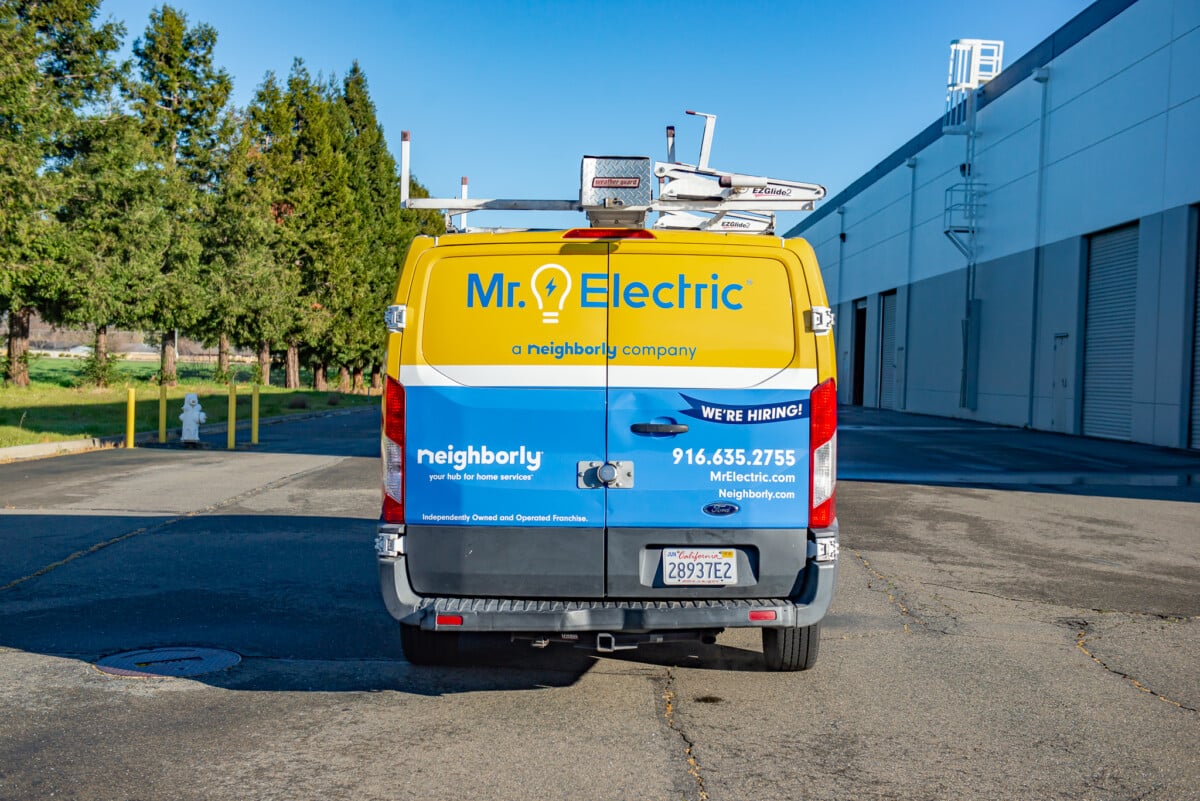 Back of custom commercial vehicle showcasing brand, logo, and contact information. 
