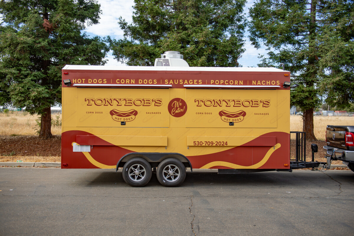Full wrap design for Tony Bobs's Hotdogs truck in cool mustard yellow, with brown typography, graphics, and hotdog themed illustrations.